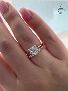 a woman's hand with two engagement rings on top of her finger and the other half