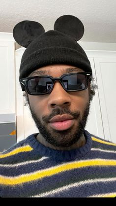 a man wearing sunglasses and a mickey mouse hat