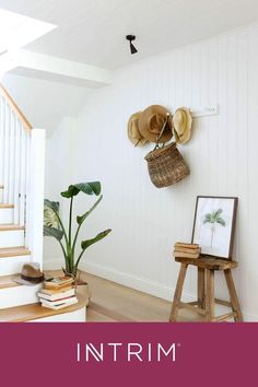 there is a hat rack on the wall next to a chair and a potted plant