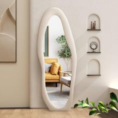 an oval shaped mirror in the middle of a living room next to a couch and potted plant