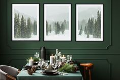 a dining room with green walls and three pictures on the wall, one has candles in front of it