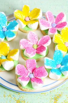 colorful flower cookies on a plate with sprinkles