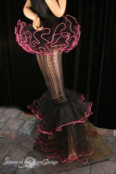 a mannequin wearing a black dress with pink lights on it's skirt