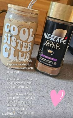 two jars filled with coffee sitting on top of a counter next to a pink heart