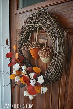 a wreath with two acorns hanging from it's side on a door