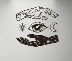 a wall decal with an eye and two hands holding the sun, moon and stars