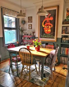 a dining room table surrounded by chairs in front of a book shelf filled with books