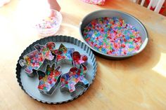 two pans filled with colorful sprinkles next to each other on a table