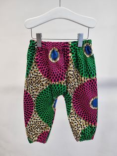 African Print Ankara Baby Trousers  A long bloomer style, gathered and elasticated at the bottom of legs.  To fit; 0-3 months with 14 inch elasticated waist  3-6 months with 15 inch elasticated waist 6-9 months with 16 inch elasticated waist 9-12 months with 17 inch elasticated waist 1-2 years with 18 inch elasticated waist 2-3 years with 19.5 inch elasticated waist 3-4 years with 21 inch elasticated waist  Please note placement of pattern may vary. Cool handwash.  To view my full range please v Red Bottoms For Playtime In Spring, Bottoms With Elastic Waistband For Playtime, Stretch Multicolor Harem Pants With Elastic Waistband, Multicolor Stretch Harem Pants With Elastic Waistband, Multicolor Bottoms With Elastic Waistband For Playwear, Red Bottoms For Spring Playtime, Red Bottoms For Spring Playwear, Green Bottoms With Elastic Waistband For Playwear, Red Bottoms With Elastic Waistband For Playwear