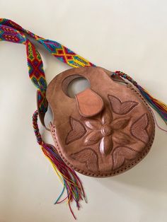 This unique leather purse is hand tooled by Artisans in Mexico. Each bag is unique and one of a kind. It is tooled on the front only, can be used as a shoulder bag or crossbody. Measurements: Multicolor woven belt strap measuring 56 in. Length: 10 in. Height: 12 in. Width: 3.5-4 in. Soft Leather Shoulder Bag For Festivals, Hand-stitched Crossbody Bags For Everyday Use, Leather Bag With Removable Pouch For Festivals, Brown Leather Hand-stitched Bag, Brown Hand-stitched Leather Bag, Leather Tote Bag For Festival, Natural Leather Shoulder Bag With Handles, Bohemian Brown Hand-stitched Bags, Handmade Leather Hobo Bag In Pouch Shape