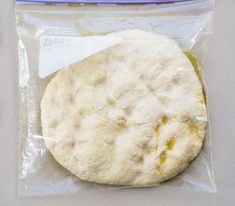 an uncooked pizza sitting on top of a plastic bag