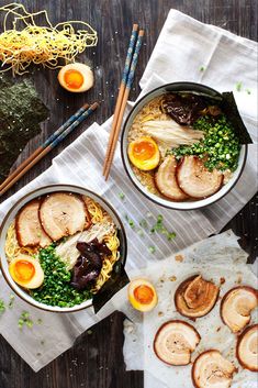 two bowls filled with meat and noodles next to chopsticks on top of a table