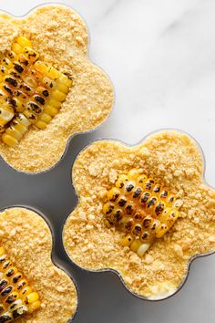 three muffin tins filled with corn on the cob and topped with crumbs