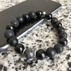 Lava Stone, Matte Black Onyx, And Onyx 10mm Bracelet w/ Silver Accents Mixed, matched, and designed with a variety of elegant beads for a graceful look. This is a beautiful piece made to be worn separately or combined with our other Embody'd Art pieces! This bracelet can also be worn as an oil diffuser. Just add one drop of your favorite oil to the AAA grade lava beads and you're set to go. This bracelet is crafted with quality elastic stretch cord. This bracelet is also designed to fit snug on Adjustable Black Lava Stone Beaded Bracelets, Black Bead Bracelet, Black Lava Stone Spiritual Bracelets, Casual Hand-strung Beaded Bracelets With Lava Stone, Casual Hand-strung Lava Stone Beaded Bracelets, Black Hand-strung Lava Stone Beaded Bracelets, Lava Stone Bracelet, Black Beaded Bracelets, Black Bracelet