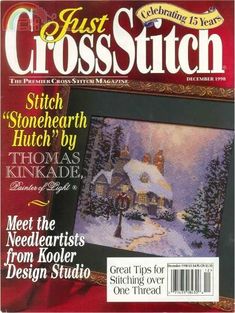 the cover of just cross stitch magazine featuring a winter scene with a house and trees