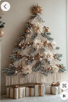 a christmas tree decorated with gold and white ornaments, wrapped presents under the tree is an ornament that hangs on the wall