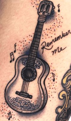 a tattoo with an acoustic guitar and musical notes on it's side ribcage