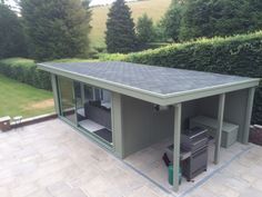 an outdoor storage shed is shown in the middle of a yard with grass and bushes