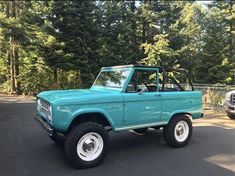 an old blue pickup truck parked in a parking lot