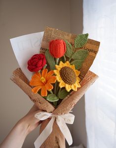 a person holding a bouquet of crocheted flowers