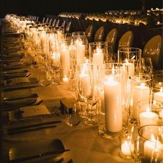 a long table is set with candles and place settings for dinner guests to sit at