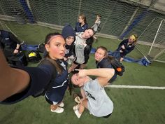 a group of young women standing next to each other on top of a soccer field