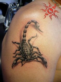 a scorpion tattoo on the back of a woman's shoulder