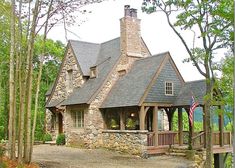 a stone house surrounded by trees in the woods