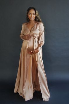 The Satin Rose is delicate and soft, both to the touch and the eye, her grace and style is effortless. A head tuner for any mum-to-be this spring. The Satin Rose Gown is a silky wrap style dress which features an elasticated waist and belt with front split detail. Color Options: Bronze Gold, Champagne, Pink Wrap Gowns, Baby Shower Gown, Luxury Baby Shower, Formal Maternity Dress, Rose Gown, Dolly Dress, Gold Gown, Plus Size Gowns, Satin Roses