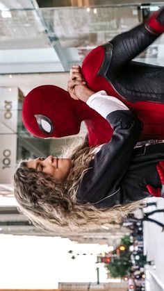 a woman dressed as spider - man flying through the air