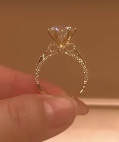 a person holding up a diamond ring in their hand