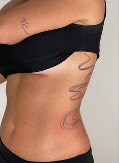 a woman's stomach with tattoos on the side and her lower body is shown