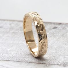 a gold wedding ring with an intricate design