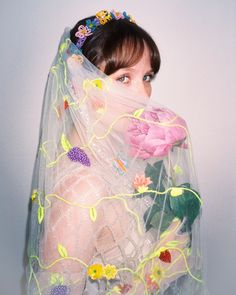 a woman wearing a veil with flowers on it