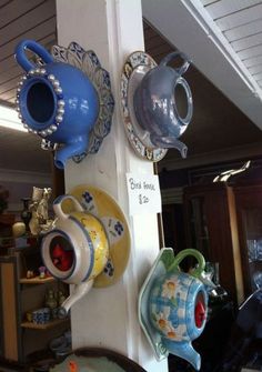 tea cups and saucers are hanging on the wall