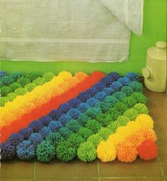 a rainbow rug on the floor next to a towel rack