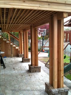 an outdoor patio with wooden posts and benches