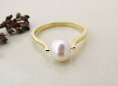 "♥ Unique minimalist pearl ring in 14k solid gold. This ring featuring beaded freshwater white pearl at the top. Simple but special ! ♥ Perfect for an engagement ring - the symbol of purity and innocence. ♥ This dainty ring fits your everyday wear, and also will be wonderful to be given as a gift. ♥ The pearl is 7-8 mm in diameter. The ring width is max. 3 mm. ♥ You can choose between yellow gold/ white gold or rose gold - select your preference. ♥ This ring comes in shiny finish but also can be Minimalist Pearl Drop Ring For Wedding, Minimalist Wedding Pearl Ring With Pearl Drop, Minimalist Pearl Drop Ring For Anniversary, Simple Pearl Ring For Wedding, Minimalist Pearl Drop Ring For Gift, Minimalist Pearl Drop Ring For Promise, Minimalist Pearl Promise Ring, Classic White Pearl Ring With Simple Design, Minimalist Pearl White Pearl Ring