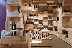 the shelves are filled with wine bottles and wooden crates in order to display them,