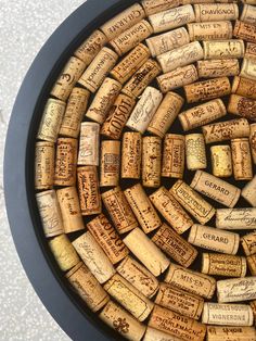 a black plate with lots of wine corks on it's sides and some writing on the inside