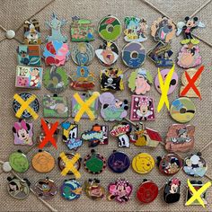 many different disney pins and magnets are on the floor next to each other, including mickey mouse