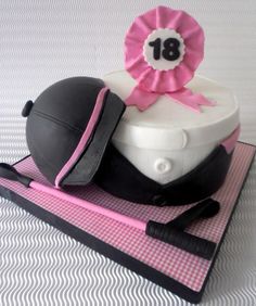 a birthday cake with a hat and pink ribbon