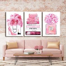 two paintings on the wall above a pink couch and coffee table with flowers in vases