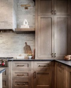 a kitchen with wooden cabinets and marble counter tops