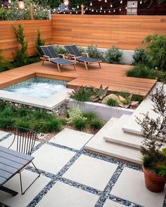 an outdoor hot tub in the middle of a patio with chairs and lights above it