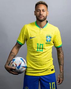 a man holding a soccer ball in his right hand and wearing a yellow shirt with the number 11 on it