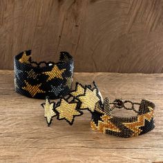 three beaded bracelets sitting on top of a wooden table next to each other