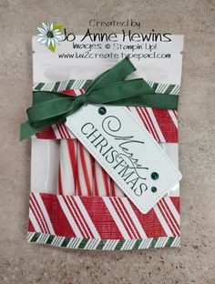 christmas candy canes wrapped in red and green paper with a tag on it's side