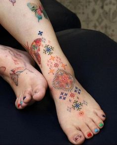 a woman's foot with colorful tattoos on it