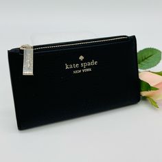 Brand New With Tag Kate Spade Leila Small Slim Bifold Wallet Details Color: Black 3.1" H X 5.5 Wx 0.9" D Pebbled Leather Metal Pinmount With Spade Logo Two Way Spade Jacquard Lining 5 Credit Card Slots, Id Window, 2 Slip Pockets Exterior Top Zip Coin Compartment On Front Of Wallet Snap Closure Dust Bag Not Included Imported Style # Wlr00395 Chic Black Wallet With Zipper Pouch, Kate Spade Bifold Coin Purse, Kate Spade Bifold Wallets For Gifts, Compact Kate Spade Coin Purse, Chic Kate Spade Bifold Wallet, Chic Kate Spade Evening Wallet, Kate Spade Coin Purse For Daily Use, Kate Spade Compact Wallet For Everyday, Kate Spade Evening Wallet With Card Slots